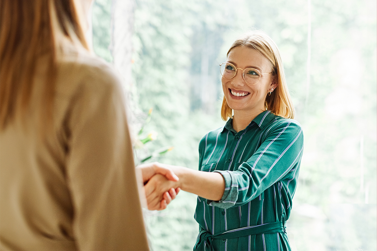 women shaking hands in office